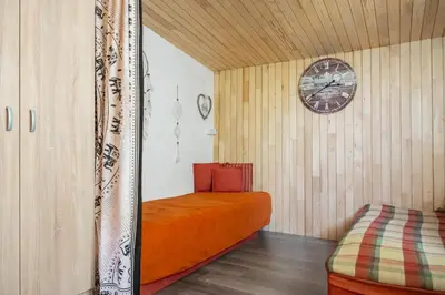 a room with a bed and a clock on the wall at Orange Apart in Ulcinj