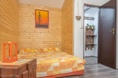 a bedroom with a bed and a wooden wall at Orange Apart in Ulcinj