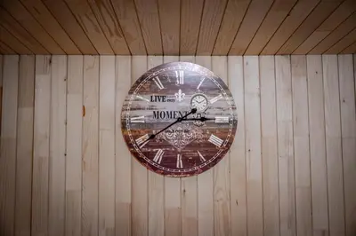 a clock is hanging on a wooden wall at Orange Apart in Ulcinj