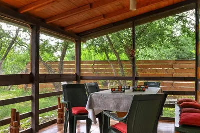 a table and chairs on a screened in porch at Orange Apart in Ulcinj
