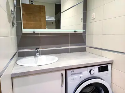 a bathroom with a sink and a washing machine at Nature Escape Infinity Pool and Amazing Sea View in Budva