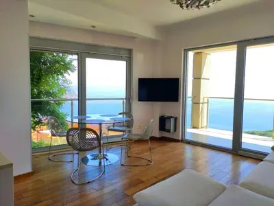 a living room with a table and a view of the ocean at Nature Escape Infinity Pool and Amazing Sea View in Budva