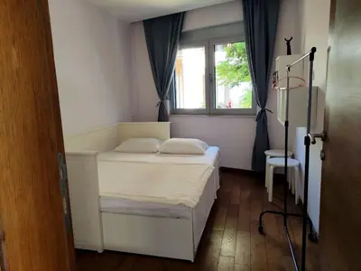 a small bedroom with a bed and a window at Nature Escape Infinity Pool and Amazing Sea View in Budva