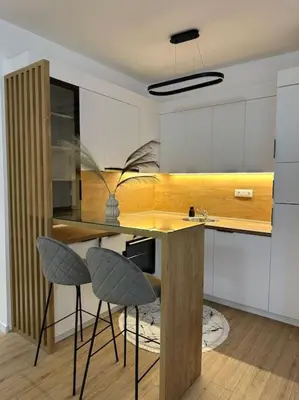 a kitchen with a counter and two stools in it at Swiss Apartments 1 in Ulcinj