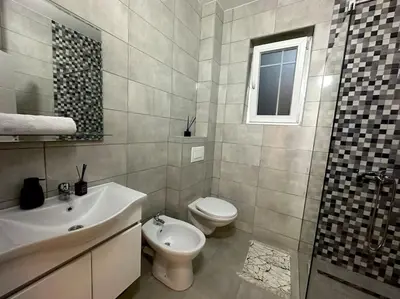 a bathroom with a sink and a toilet and a shower at Swiss Apartments 1 in Ulcinj