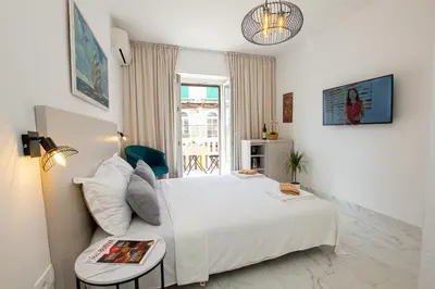a bedroom with a white bed and a table at Marco Polo in Petrovac na Moru