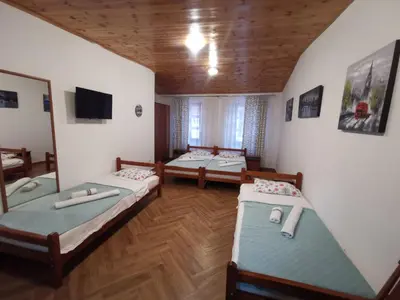 a room with three beds and a tv in it at Old Town - Guest House in Stari Bar