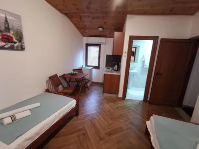 a room with a bed and a table and a bathroom at Old Town - Guest House in Stari Bar