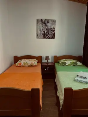 a room with two beds with a zebra picture on the wall at Old Town - Guest House in Stari Bar