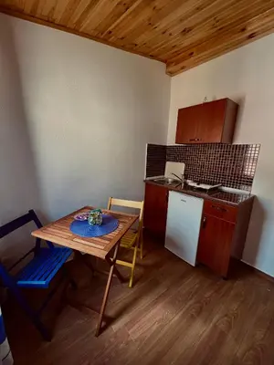 a small kitchen with a wooden table and a table and a counter at Old Town - Guest House in Stari Bar