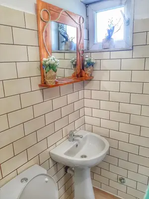 a bathroom with a sink and a toilet and two mirrors at RAINBOW HOME in Gornji Štoj