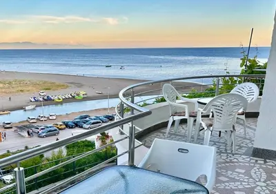 a balcony with a table and chairs and the beach at Romantica Apartments in Ulcinj