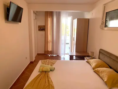 a bedroom with a bed and a tv on the wall at Romantica Apartments in Ulcinj