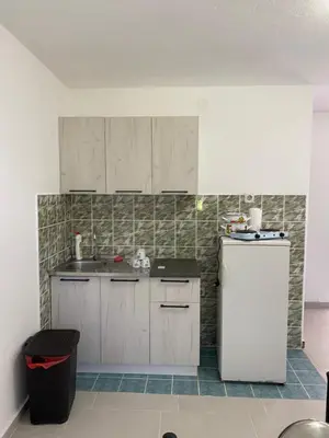 a kitchen with white cabinets and a refrigerator at Guest House in Utjeha in Utjeha