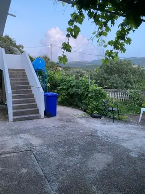 a stairway with a blue trash can and a blue trash can at Guest House in Utjeha in Utjeha