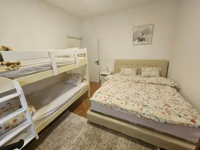 a bedroom with two bunk beds and a rug at Perovic 23 in Rafailovici