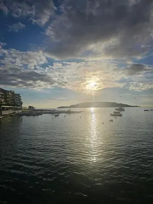 a sunset over a large body of water with boats at Perovic 23 in Rafailovici