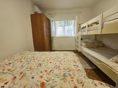a bedroom with two bunk beds and a bedspread with flowers at Perovic 23 in Rafailovici