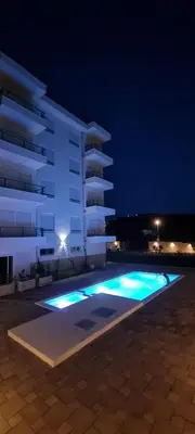 a swimming pool in front of a building at night at Cold Bay Mansion Luxury Sea View Suites in Bar