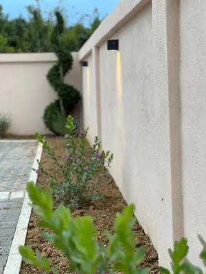 a fence with some plants next to a building at Cold Bay Mansion Luxury Sea View Suites in Bar