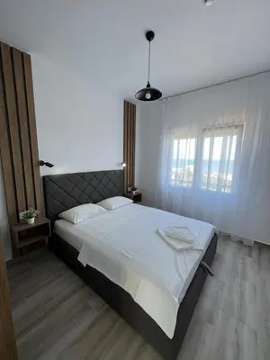 a bedroom with a large bed with white sheets at Cold Bay Mansion Luxury Sea View Suites in Bar
