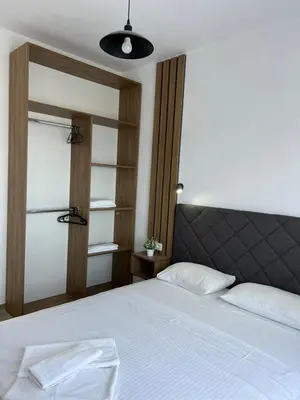a bedroom with a white bed with a black headboard at Cold Bay Mansion Luxury Sea View Suites in Bar