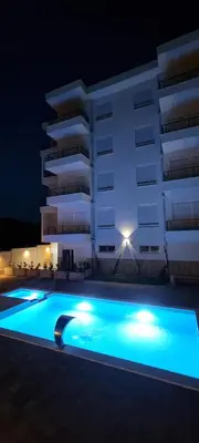 a swimming pool in front of a building at night at Cold Bay Mansion Luxury Sea View Suites in Bar