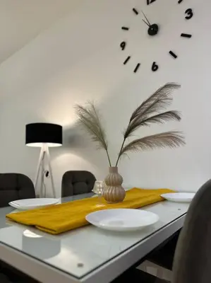 a table with plates and a clock on the wall at Swiss Apartments 2 in Ulcinj