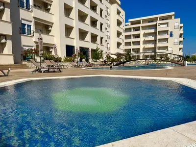 a large swimming pool in front of a building at Swiss Apartments 2 in Ulcinj