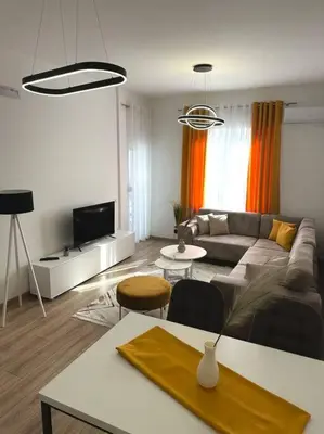 a living room with a couch and a tv at Swiss Apartments 2 in Ulcinj