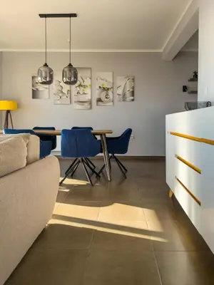 a living room with a table and blue chairs at Golden Horizon Villas in Budva