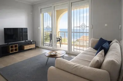 a living room with a couch and a view of the ocean at Golden Horizon Villas in Budva