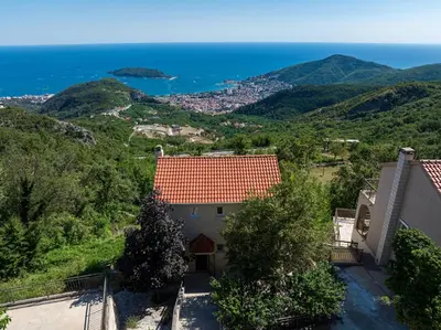 a house with a red roof and the ocean at Golden Horizon Villas in Budva