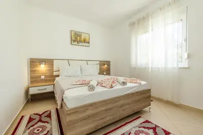 a bedroom with a large bed and a window at DITJONI in Ulcinj