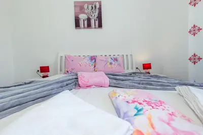 a bedroom with a bed with blue and pink sheets at DITJONI in Ulcinj