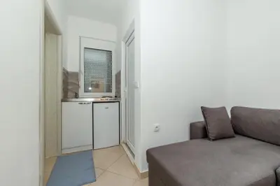 a living room with a couch and a kitchen at DITJONI in Ulcinj