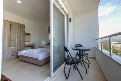 a bedroom with a bed and a table and chairs at DITJONI in Ulcinj