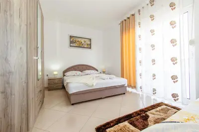 a bedroom with a bed and a large window at DITJONI in Ulcinj