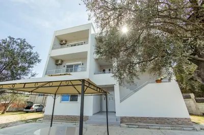 a white building with an umbrella in front of it at DITJONI in Ulcinj