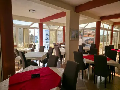 a dining room with tables and chairs and windows at BOGUMILA in Bar