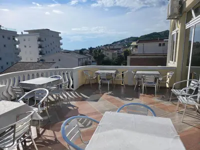 a balcony with tables and chairs on a building at BOGUMILA in Bar