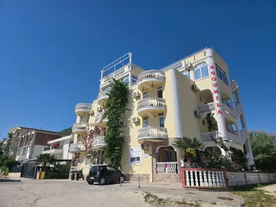 a large yellow building with balconies and a car parked in front at BOGUMILA in Bar