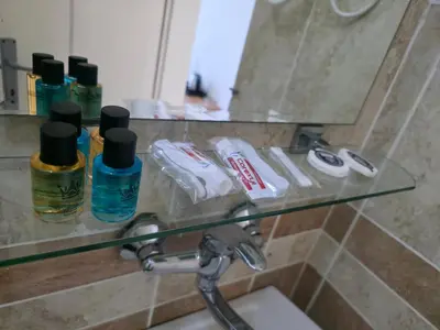 a bathroom with a glass shelf above a sink at BOGUMILA in Bar