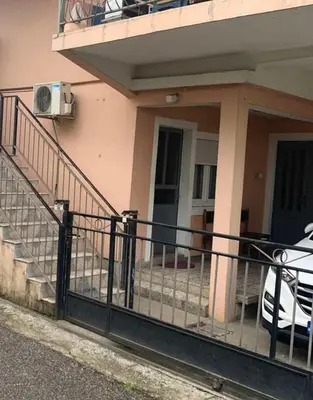 a house with a balcony with a car parked outside at NIKOLA studio in Podgorica