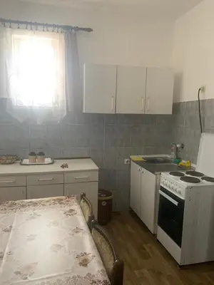 a kitchen with a stove and white cabinets and a window at NIKOLA studio in Podgorica
