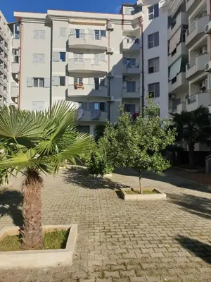 a palm tree in a courtyard in front of a building at Apartment Rozino in Budva