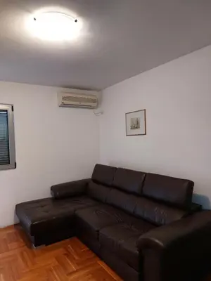 a living room with a brown leather couch in a room at Apartment Rozino in Budva