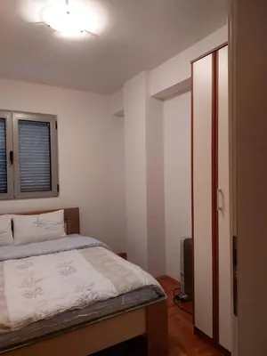 a bedroom with a bed and an open door at Apartment Rozino in Budva