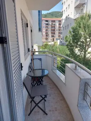 a small balcony with a glass table and a view of a city at Apartment Rozino in Budva