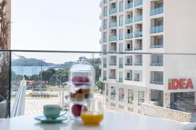 a glass bottle sitting on a table with a cup of orange juice at Adriatic Dream Apartment Becici in Budva